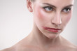 Close-up of a woman's face with make-up and smudged lipstick