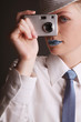 Woman with rhinestones on her lips taking picture with digital camera