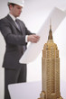 Model of Empire State Building, businessman reading blueprint in the background