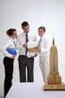 Model of Empire State Building, business people having discussion in the background