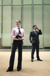 Businesswoman writing on organizer, businessman talking on the phone