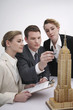Business people examining model of Empire State Building