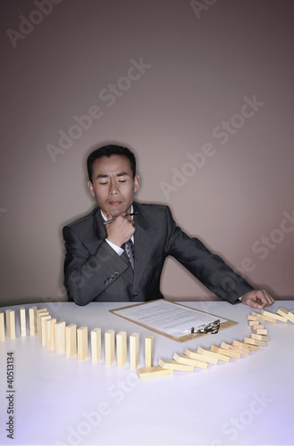 Photo: Businessman examining wooden blocks on the table Businessman examining wooden blocks on the table