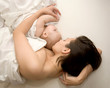 Pretty  mother and baby sleeping in bed. A mother's love.