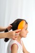 Mother combing her child's hairs.