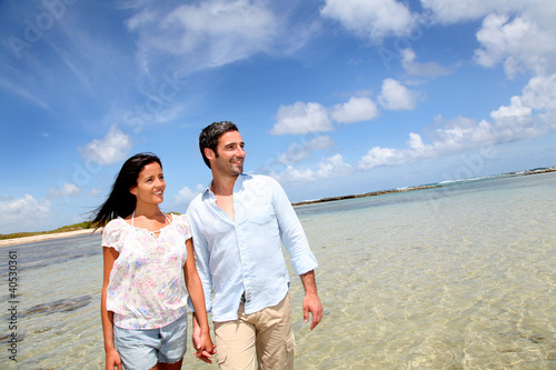 Photo: Cheerful couple walking by the sea Cheerful couple walking by the sea