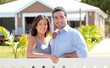 Couple standing in front of new home