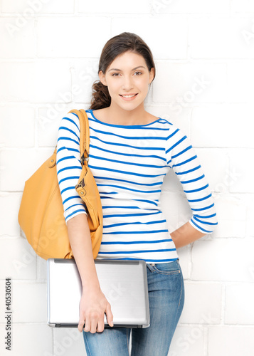 Photo: happy and smiling teenage girl with laptop happy and smiling teenage girl with laptop