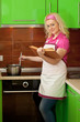 Blonde reading a book and preparing food on kitchen