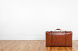 Photo: Vintage leather suitcase on a wooden floor Vintage leather suitcase on a wooden floor