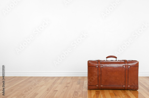 Photo: Vintage leather suitcase on a wooden floor Vintage leather suitcase on a wooden floor