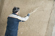 Plasterer at stucco work with liquid plaster