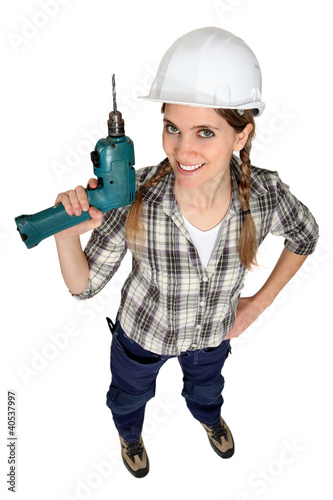 Photo: A female construction worker holding a drill. A female construction worker holding a drill.