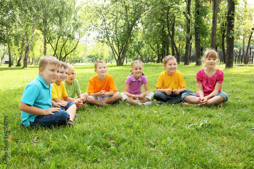 Photo: Group of children sitting together in the park Group of children sitting together in the park