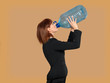 attractive, young businesswoman drinking water, big bottle