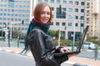A woman and her laptop at the city