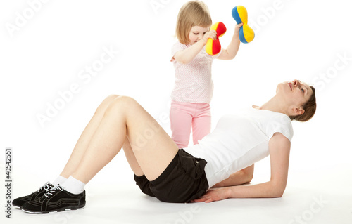 Photo: Young mother and her little daughter doing sport exercises Young mother and her little daughter doing sport exercises