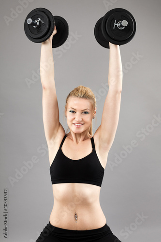 Photo: Athletic young lady working out with weights Athletic young lady working out with weights