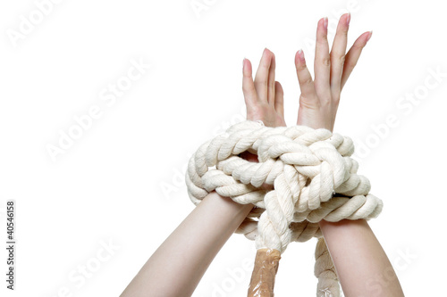 Foto: female hands tied up with rope over white female hands tied up with rope over white