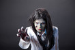 Aggressive zombie girl stretching her hand