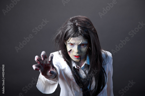Foto: Aggressive zombie girl stretching her hand Aggressive zombie girl stretching her hand