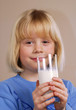 Niña bebiendo un vaso de leche.