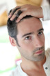 Man in front of mirrror looking at his hair