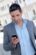 Businessman using mobilephone out in town