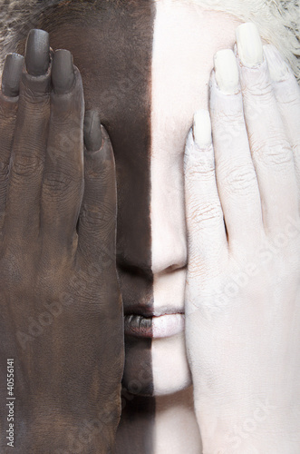 Photo: woman in the two-color makeup covers eyes woman in the two-color makeup covers eyes