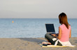 Woman Working at Computer on the Beach Woman Working at Computer on the Beach