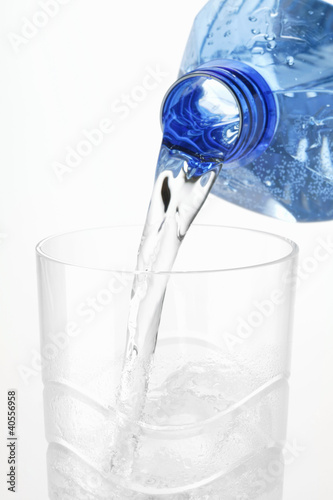 Photo: Pouring water out of plastic bottle into glass Pouring water out of plastic bottle into glass