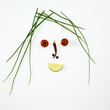 Face made from chives, vegetables and lime