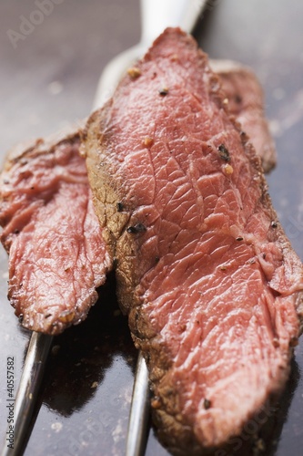 Photo: Two slices of beef steak on meat fork Two slices of beef steak on meat fork