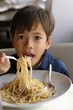 Small boy eating spaghetti