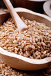 farro in ciotola di legno con cucchiaio - tre