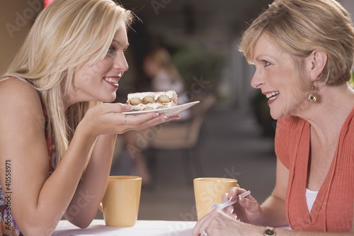 Photo: Two women in a café with a piece of tiramisu Two women in a café with a piece of tiramisu