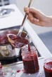 Foto: Raspberry jam being ladled into a screw-top jar Raspberry jam being ladled into a screw-top jar