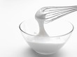 Whipped cream in bowl with whisk