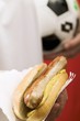 Footballer holding hot dog (sausage & mustard in bread roll)