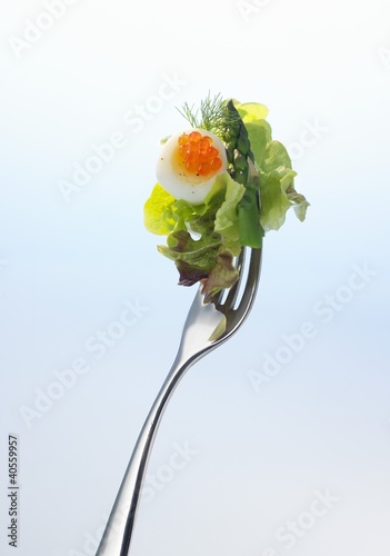 Foto: Lettuce, asparagus, quail's egg and red caviar on a fork Lettuce, asparagus, quail's egg and red caviar on a fork