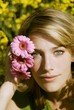 Young woman putting pink gerberas behind her ear