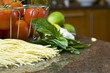 Tomatoes in wire basket with pasta and herbs