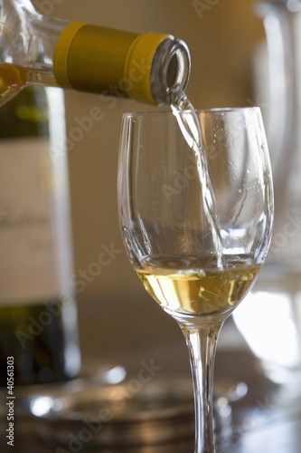 Photo: White wine being poured into a glass White wine being poured into a glass