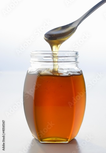 Photo: Honey running from spoon into jar Honey running from spoon into jar