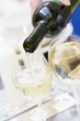 White Wine Pouring from Bottle into Glass; White Background