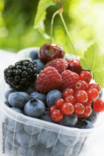 Photo: Assorted berries and two cherries in plastic punnet Assorted berries and two cherries in plastic punnet