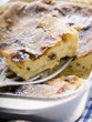 Curd cheese strudel in baking tin with piece on server