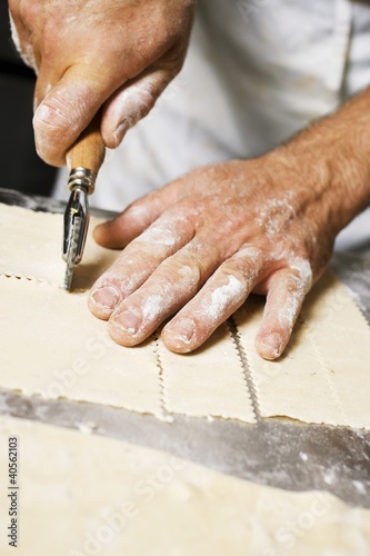 Photo: Cutting pasta dough into strips with pastry wheel Cutting pasta dough into strips with pastry wheel