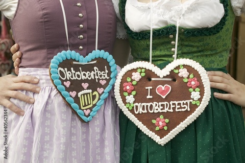 Photo: Two women in national dress with Lebkuchen hearts at Oktoberfest Two women in national dress with Lebkuchen hearts at Oktoberfest