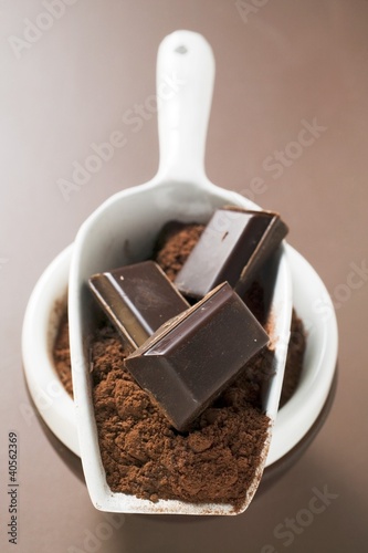 Photo: Pieces of chocolate and cocoa powder in scoop and bowl Pieces of chocolate and cocoa powder in scoop and bowl